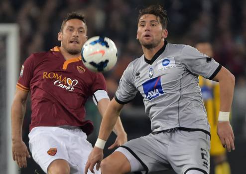 Totti in lotta con Stendardo. Afp